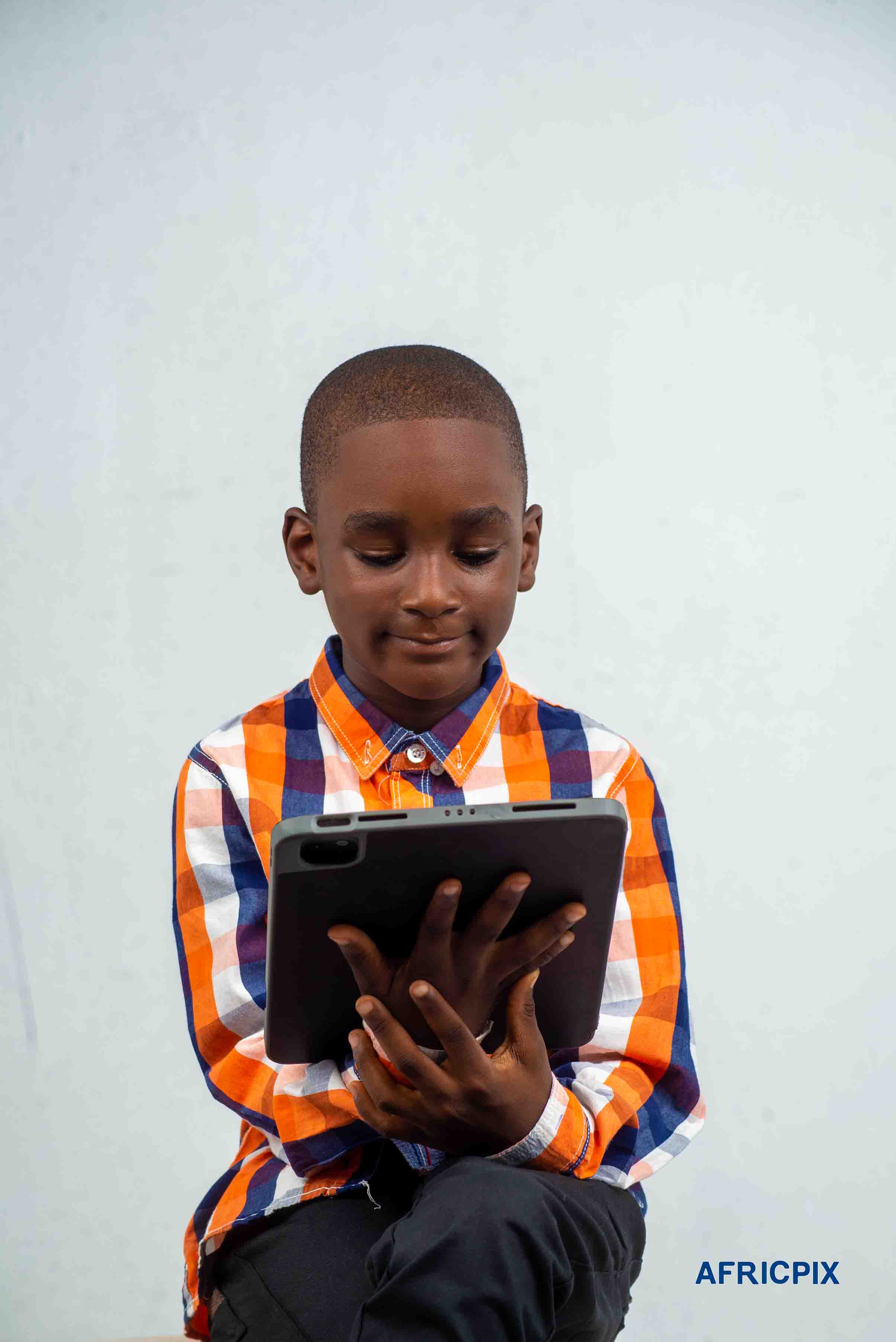 Nigeria Child Boy Sitting Smiling Looking Tablet Ipad